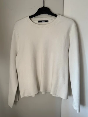 Vit stickad tröja från BikBok - Klassisk vit stickad tröja från BikBok med rund halsringning och långa ärmar. Tröjan har en enkel och stilren design som passar till det mesta. Mjuk och skön kvalitet, perfekt för lager på lager under kyligare dagar.