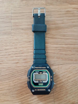 Vintage C-SHOCK Digital Klocka - Digital klocka med svart boett och svart armband. Klockan har en digital display som visar tid och veckodag. Boetten är märkt med "PROTECTION" och "200M". Säljes i befintligt okänt skick.  Se gärna mina andra annonser!