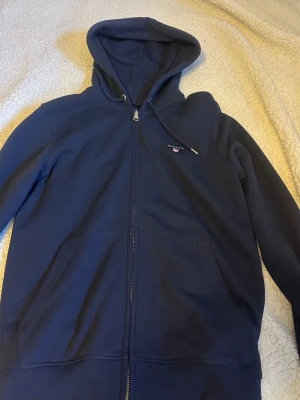 Marinblå zip hoodie från Gant - Marinblå hoodie från Gant med dragkedja, Säljer då den är för liten för mig.