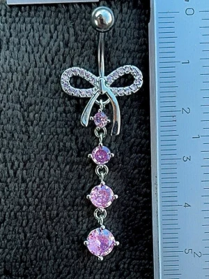 NY oanvänd Navelpiercing med hänge | Kirurgiskt stål | Rosett och rosa stenar  - 💕30% Bundle-rabatt vid köp av minst 2 artiklar. ⭐️NY oanvänd piercing i kirurgiskt stål; rostfritt och säkert för läkta piercingar.                               📏MÅTT ⭕️Stavens längd: 10mm ⭕️Stavens tjocklek: 1,6mm ⭕️Smyckets totala längd: 50mm                                                                         🤍Färger: Silver och rosa                                                            💌Skickas spårbart via Plick SafePay.