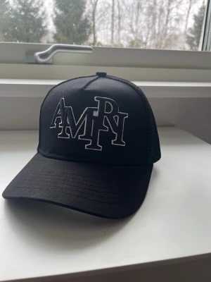 Svart truckerkeps från Amiri - Svart truck keps från amiri, helt svart med vita bakgrunds nyanser av märket, kepsen är i helt nytt skick och helt oanvänd, riktigt fin och passar alla tillfällen, har en kollektion och vill bli av med de.