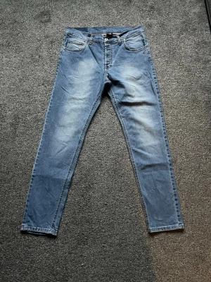 Blå Dondups - Snygga Dondup jeans i blå tvätt med slim passform. Stilrena fade-detaljer som ger en modern look. Storlek 33 📦 Skick: Bra begagnat skick, se bilder.
