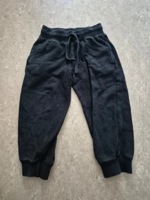 Mjukisbyxor - Ett par svarta mjukisbyxor med resår i midjan och dragsko för skön passform. Byxorna har muddar vid bensluten och två sidofickor. Perfekta för chill eller träning. Tillverkade i mjukt sweatshirtmaterial.