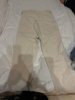 Beiga raka jeans i bomull - Snygga beiga jeans med rak passform och klassisk femficksdesign. Tillverkade i mjuk bomull som känns skön mot huden. Perfekta för dig som vill ha ett par stilrena och neutrala jeans att matcha med allt.