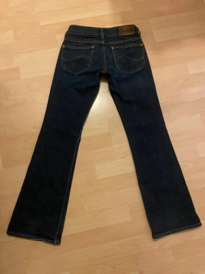 Lågmidjade bootcut jeans från Lee - Snygga mörkblå lågmidjade jeans från Lee! mycket bra skick, inga defekter. Storlek W25 L31. Postar inom 24h📦 Tveka inte på att höra av er vid frågor eller funderingar!🩷