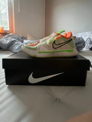 Nike PG 4 gatorade - Säljer ett par Nike PG 4 sneakers i vitt och ljusgrönt med neonorange detaljer och dragkedja på ovansidan. Skorna har meshmaterial för bra ventilation och en låg siluett. Swoosh-logga på sidan och bekväm sula med gröna accenter. Limited edition gatorade
