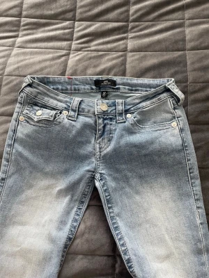 Ljusblå True Religion jeans  - Säljer ett par ljusblå jeans från True Religion då dom är lite förstora. Modell Joey. Nästan helt nya! Användt tre gånger och endast lite uppskrapade i kanten på ena benet (syns på bilden).