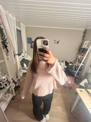 Ljusrosa stickad tröja med polokrage - Mysig ljusrosa stickad tröja med polokrage och avslappnad passform. Tröjan har långa ärmar och är perfekt för lager på lager. Passar till både jeans och mjukisbyxor för en chill look.