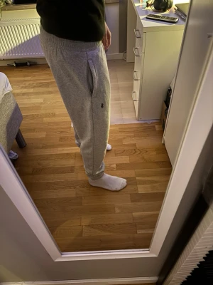 Ralph Lauren (Fake) mjukis byxor! - Snygga gråa mjukisbyxor. Byxorna har resår i midjan och muddar vid bensluten samt praktiska sidofickor. Perfekta för chill eller streetwear-stil.