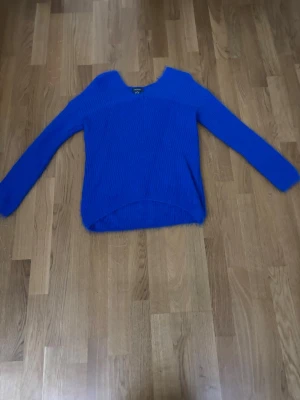 Mörkblå stickad tröja Primark - Snygg mörkblå stickad tröja från Primark med v-ringning och lång ärm. Tröjan har en något lös passform och är ribbstickad för extra struktur. Perfekt att slänga på sig när det är kyligt ute.