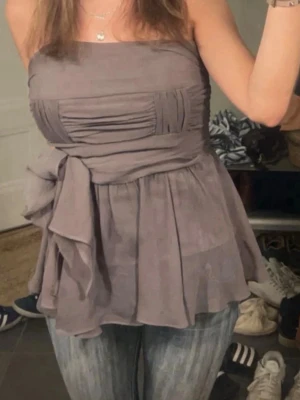 Lila topp  - Jätte söt topp utan axelband med knytning under bysten! Köpt på en marknad i Spanien och knappt använd. Storlek 40 men passar mig som har S/M