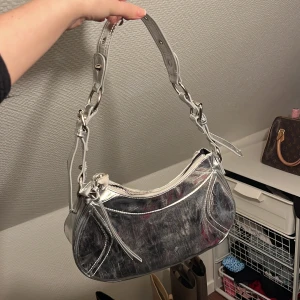 Silvrig väska - Säljer en silvrig väska från Gina tricot. Köparen står för frakten  Aldrig använd 