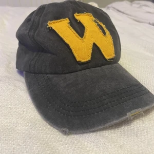 Keps - En fin jeans keps som rökt mörk grå med slitningar och gul/orange detaljer knappt använd. Köparen står för frakten!❤️