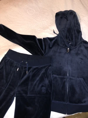 Juicy couture  - Hej säljer nu mitt juicy set i färgen mörkblå.Säljer den för jag vill ha en ny färg.Köpte den i år (September) från raglady (2200).Säljs för 1500.Båda byxorna och tröjan är i xs 