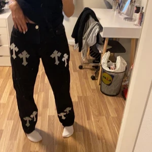 Jeans med korts - Ett par svarta jeans med gråa och vita kors på, jeansen är köpta utan kors på Gina, sydde på korsen själv, använt ganska mycket men inte min stil🖤🖤🖤
