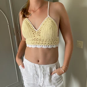 Virkad topp - Egenvirkad topp i en ljusgul pastellfärg med vita detaljer. Knyts med hjälp av snören i ryggen där du själv kan justera storlek. Storleken är XS - M i midjan och passar A - C kupor. Pris är 175 kr + frakt. Ingen retur 💛