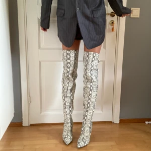 Thigh high boots - Lårhöga ormskinnsstövlar som lyser i mörkret. Aldrig använda. Frakt tillkommer. 
