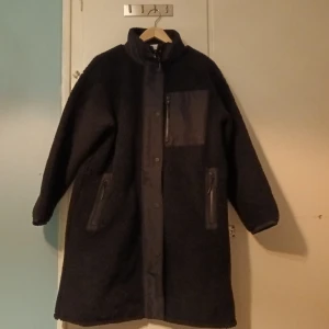 Carin Wester Anick Teddyjacka - Knälång jacka i pile. Ståkrage. Rak rymlig modell.stl S. Har en vit lina dan i stl M. Nypris 1299:-