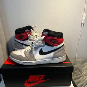 Air Jordan 1 high light smoke gray - Ett par light smoke gray. Säljs för att dom blivit för små. Ganska smutsiga men i bra skick för hur mycket dom är använda. Lådan finns kvar och svarta skosnören. Dom är köpta på soldout (en hemsida på nätet). 