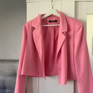 Kavaj  - En rosa jättefin rosa croppad kavaj från GinaTricot. Endast använd en kväll. Storlek 42 så den är oversize för mig som vanligtvis är en 38:a. Vilket ger en cool och snygg look! Säljes för 150 kr+frakt. Betalning sker via Swish.