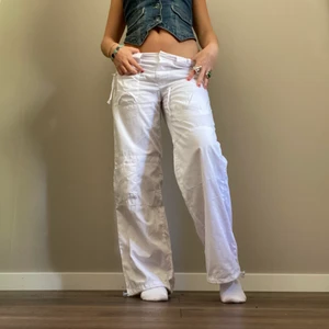 Vita lågmidjade cargobyxor  - Snygga vita cargobyxor med coola dragkedjor! Midjemått 76 cm och innebenslängd 75 cm💕 ( klicka ej på köp direkt”