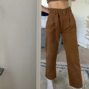 Ginatricot jeans - Ett par jättesköna highwaist jeans från ginatricot, med ett skärp i midjan. Raka i modellen, och bruna i färgen. Är i använt skick men fortfarande snygga. Lite skrynkliga på bilden, men stryker man dem blir dem jättefina igen! 