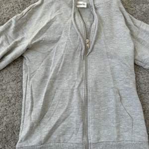 En superfin grå zip-up hoodie från Even & Odd. Inte använd en enda gång och är i nyskick. Ganska tunn tröja men perfekt till våren. I storlek XS men passar för S. Säljer pågrund av att jag ej använder den. 
