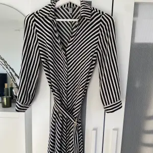 Knälång klänning ifrån H&M. I nyskick. Med knappar och spänne 