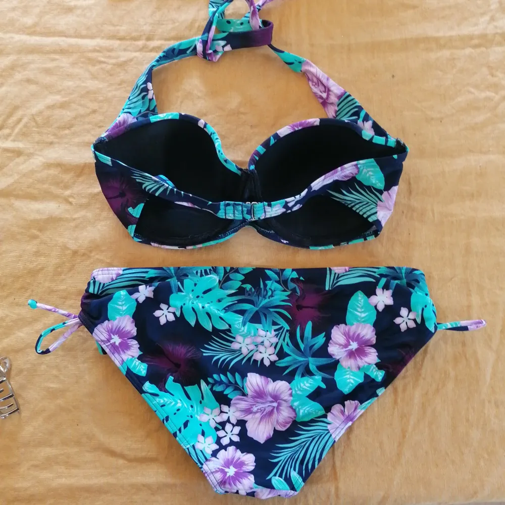 Marinblå bikini med mintgröna och ljusrosa blad/blommor. Bra support i toppen med bygel. Från warp (stadium), knappt använd, bra skick. . Övrigt.