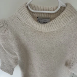 Stickad & other stories  - Offwhite stickad kortärmad tröja i alpaca/wool/polyester blend från & other stories! Strl XS, nypris runt i 1000kr (minns inte exakt). En croppad modell med lite puffiga ärmar! Säljs i befintligt skick <3 Säljer en liknande i brun, kolla min profil!