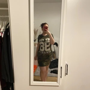 Klänning  - Klänning med militär mönster, slits på båda sidor.