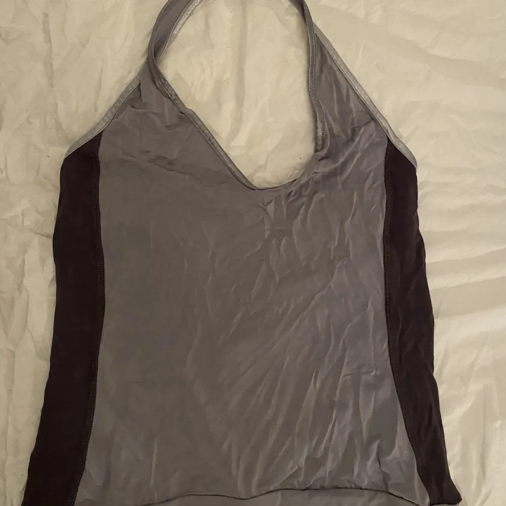 Halterneck linne i grå färg med öppen rygg. Gammal modell och i sportmaterial. . Toppar.