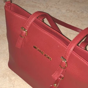 Michael kors handväska RÖD - Min mammas gamla hon vill sälja aldrig använt fick i present men va inte hennes smak:( hoppas den gör nån annan glad mvh lofve