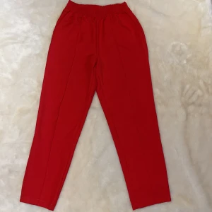 Kostymbyxor - Extremt sköna kostymbyxor i en väldigt snygg röd färg med resår i midjan! Sitter väldigt fint på kroppen!