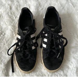 Adidas campus black  - Säljer dessa adidas campus skorna i begagnat skick. Lite slitningar men inga skador, endast att skosnöret har gått sönder längst upp på 1. Orginalförpackning ingår inte. 