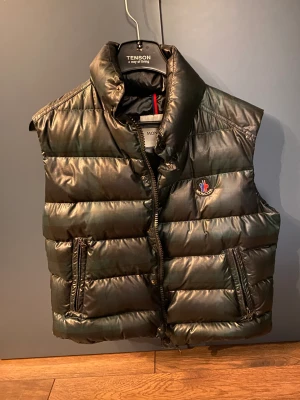 Moncler väst  - De är en grön rutig väst, den är i jätte bra skick bara att lappen på bild tre sitter lite löst. Bara att skriva om man vill ha koden. Vid snabb affär kan jag gå ner i pris. 
