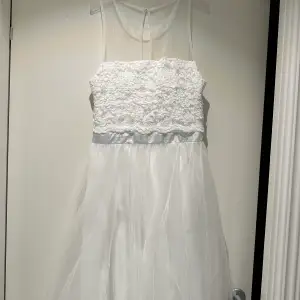 En superfin vit klänning med spets och tyll.  Perfekt ombytesklänning till bröllopet eller studentklänning.   Endast använd i 4h, så helt i nyskick.  Moments från bubbleroom 