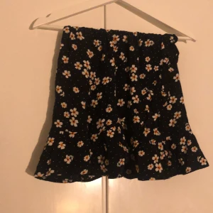 Blommig kjol - 🌺En fin svart kjol med vita blommor🌺 Använd några gånger. Väldigt fina volanger❤️