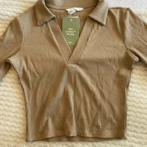 Ribbad topp med krage strl xs - Ribbad topp med krage, stretchig, aldrig använd.