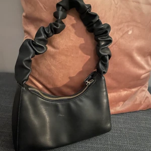 Gina väska  - En svart axelväska, med volanger. Ganska använd, så det är lite smuts som jag kan försöka få bort, men annars är den i bra skick✨60kr+frakt