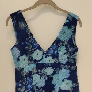 Blå vintage klänning med ett underbart mönster. - Superfin med dragkedja och djup ringning i ryggen.  Kan postas med skicka lätt om intresse finns.