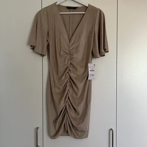 Zara beige klänning mocka imitation ny - Helt oanvänd med lappen kvar, storlek medium, men är liten i storleken.  Slutsåld 