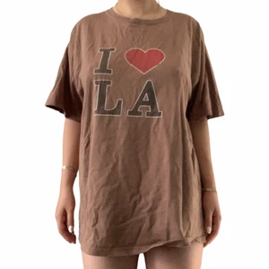 I ❤️ LA T-shirt  - Brun T-shirt med texten I ❤️ LA. Sliten och har ett hål men är fortfarande väldigt bekväm. 
