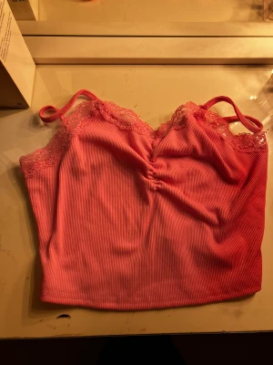 Rosa topp - Om man är runt 12-14 och har denna tröjan så är det meningen att den ska vara kort. Jag har alltid haft något under den. ( andvänd 1 gång) ingen tröja för mig. 