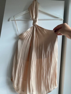 Silkigt Halternecklinne  - Halternecklinne från Mango stl xs.  Silkigt material. Liten tråddragning men syns inte när den är på! 