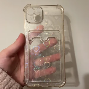 Coolt hjärt skal - Detta coola hjärtskal är till iphone 13. Det finns även ett korthållare i skalet. Man kan ta av en plastsak så det inte är några hjärtan. Då är det bara en vanligt genomskinligt skal med korthållare. Jag kommer sälja den för 10kr. 