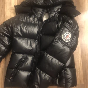 Äkta Moncler jaka  - Säljer min äkta Monckler jaka! Väl använd men i fint skikt. Är en gammal model av Moncler därför är trycket på fickan större en dom nya.