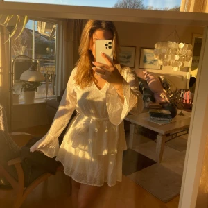 Studentklänning - Fin vit klänning till student. Resor i midjan så bra passform. Har underkjol så inte genomskinlig. Med fina volanger. Aldrig använd. Nypris: 400kr. Säljer för 180kr. 