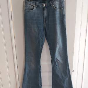 Utsvängda, mellanblå jeans i stretchigt material från Crocker. Detta var mina favoritjeans så tyvärr har dom en slitning under bälteshållarna (bild 3) men annars i fint skick