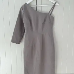 •Elegant grå klänning i nyskick •Köpt utomlands, passar XS/S •Lyxigt material, dragkedja och slits på baksidan 